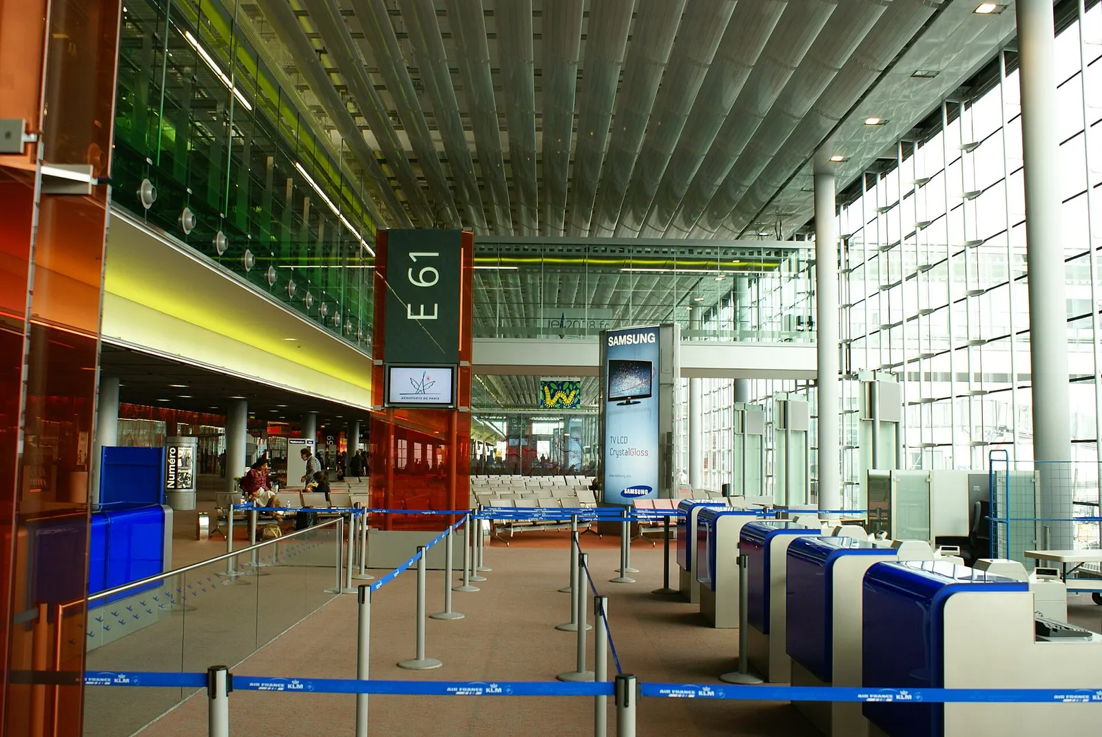 The interior concourse of Terminal E with walkways, retail, and overhead signage.
