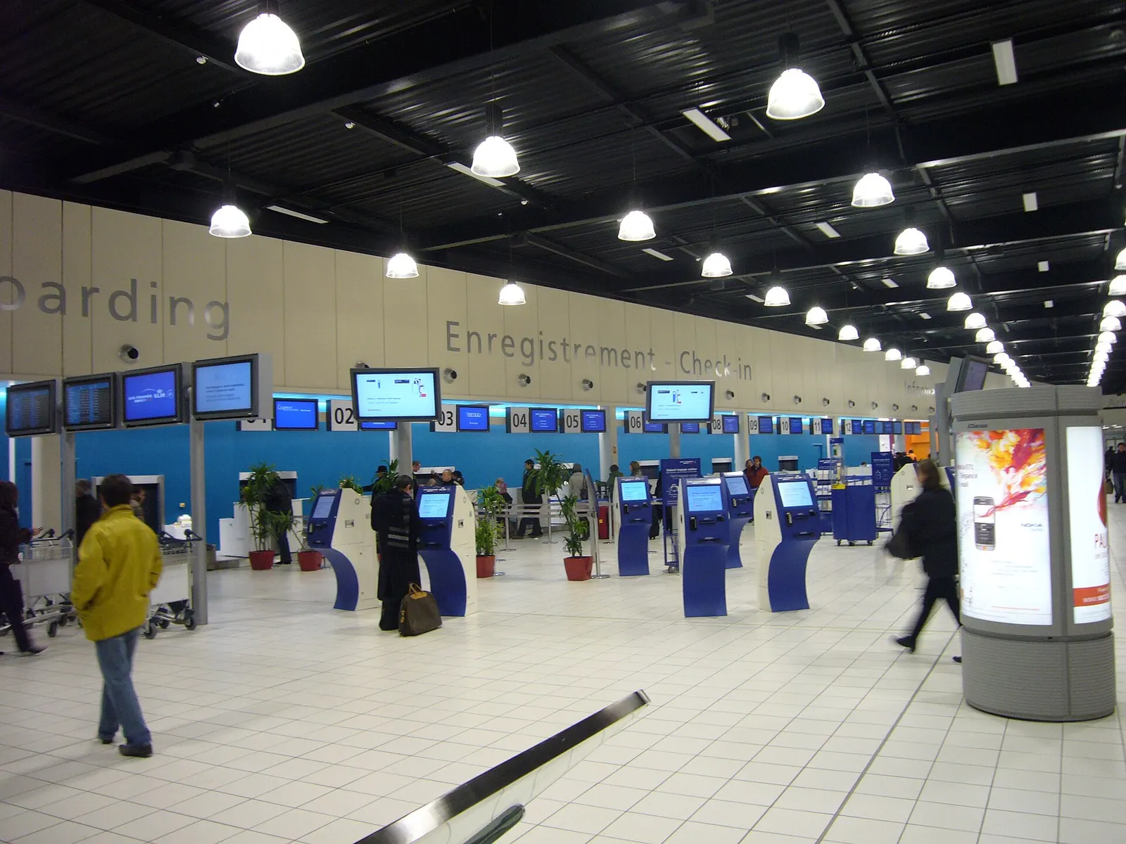 Check-in counters and airline desks line the departure hall in Terminal 2G.