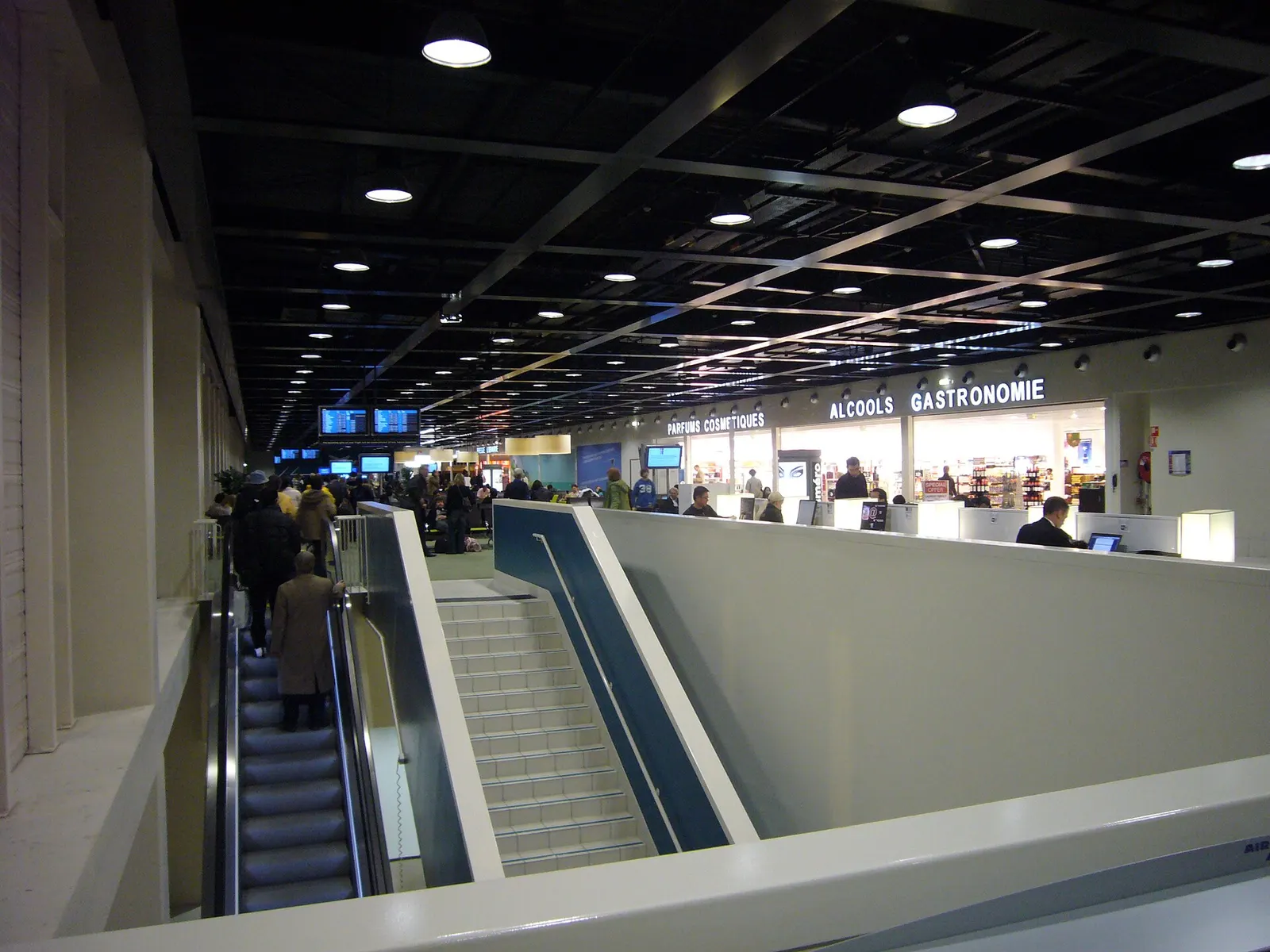 Rows of passenger seating beneath high ceilings in the boarding lounge at Terminal 2G.
