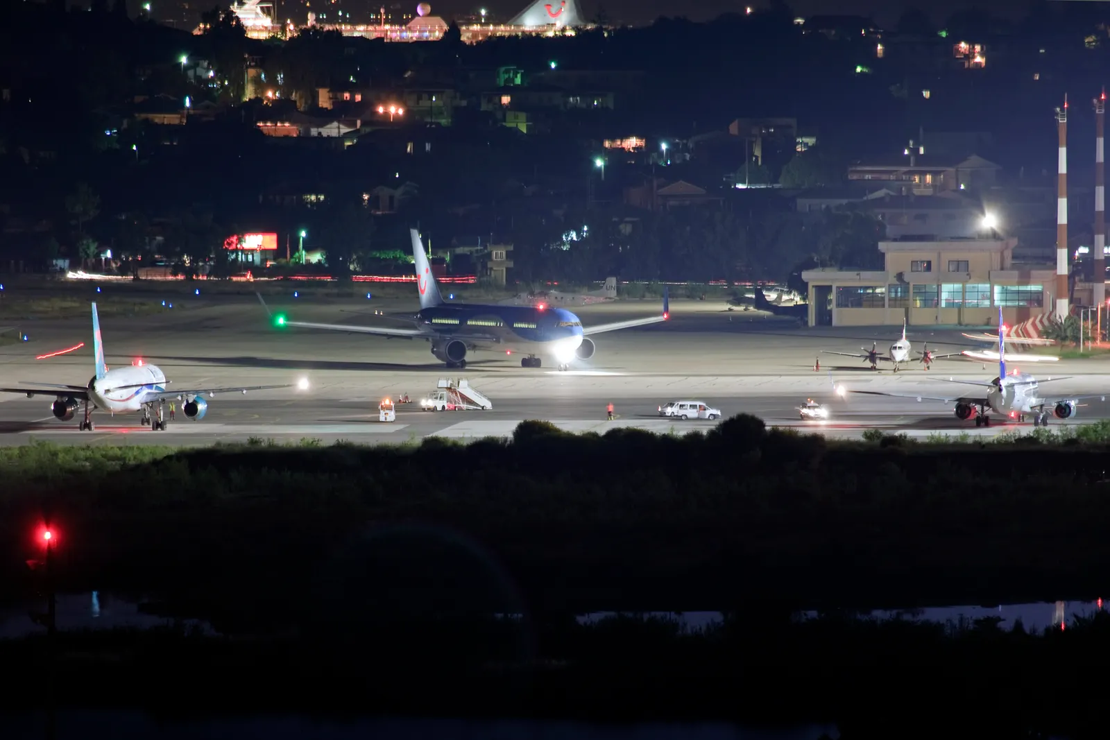 Night overview of Corfu Airport apron and terminal lights