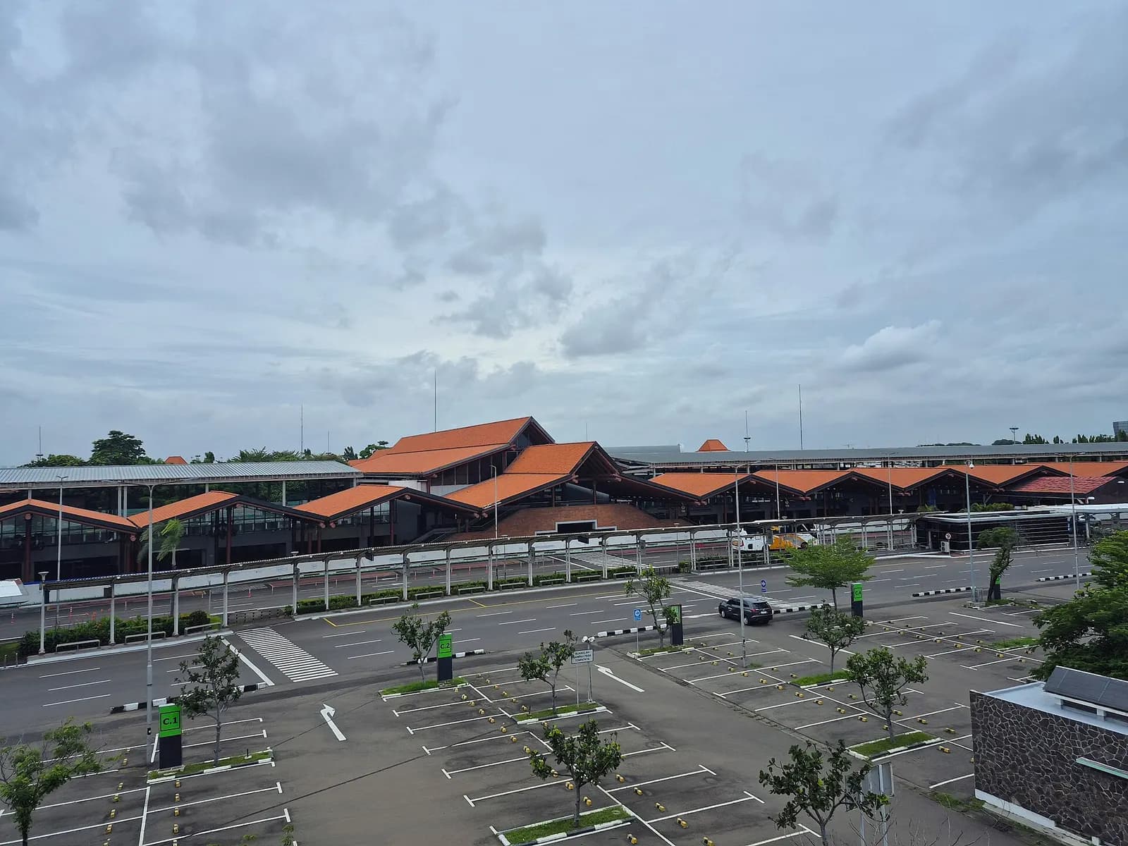 Terminal 1C building seen from the Kalayang skytrain route in 2025, with the multi-story terminal structure and surrounding airport infrastructure.