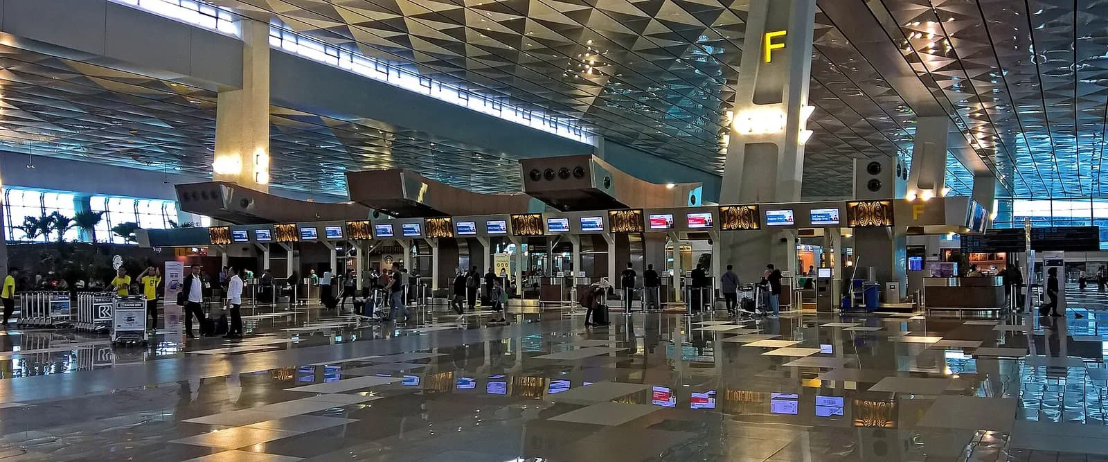 Panoramic exterior view of Terminal 3 showing its long facade, boarding bridges, and aircraft parked at gates along the apron.