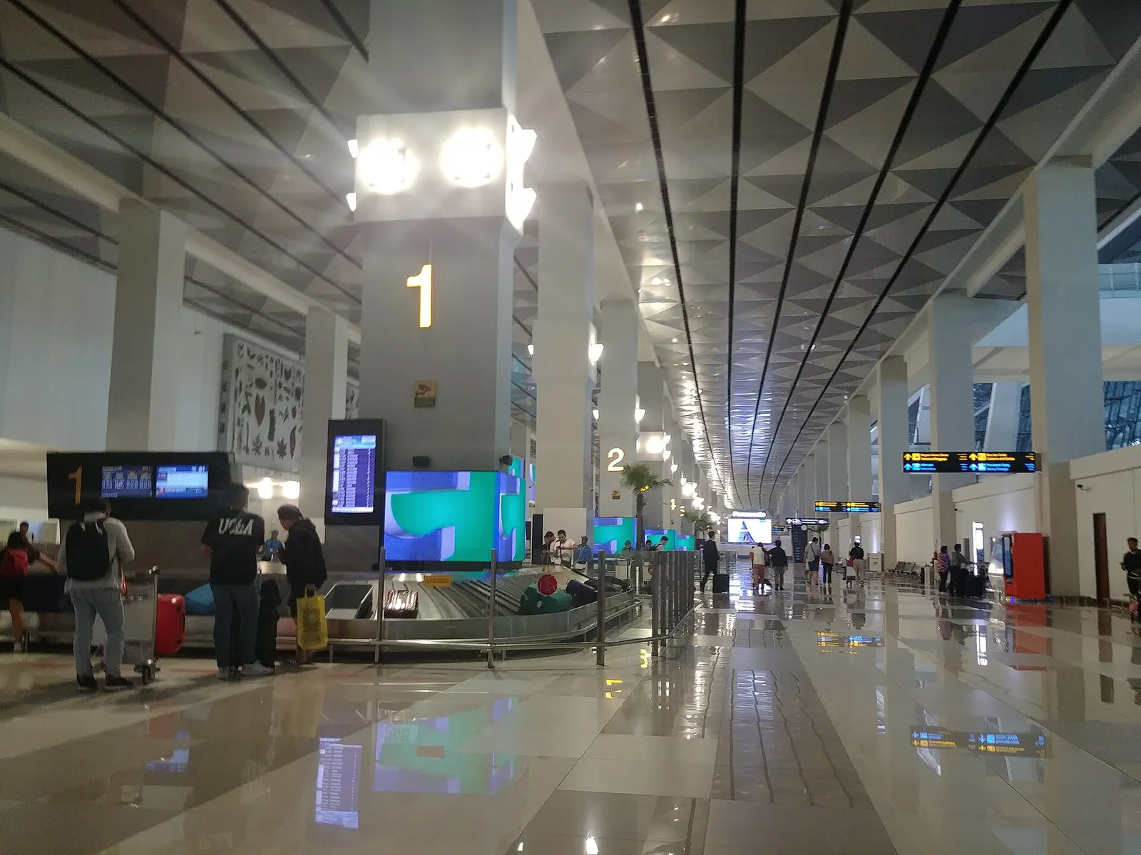 Baggage claim hall in Terminal 3 with several circular carousels, overhead signs, and a mostly empty arrivals floor.