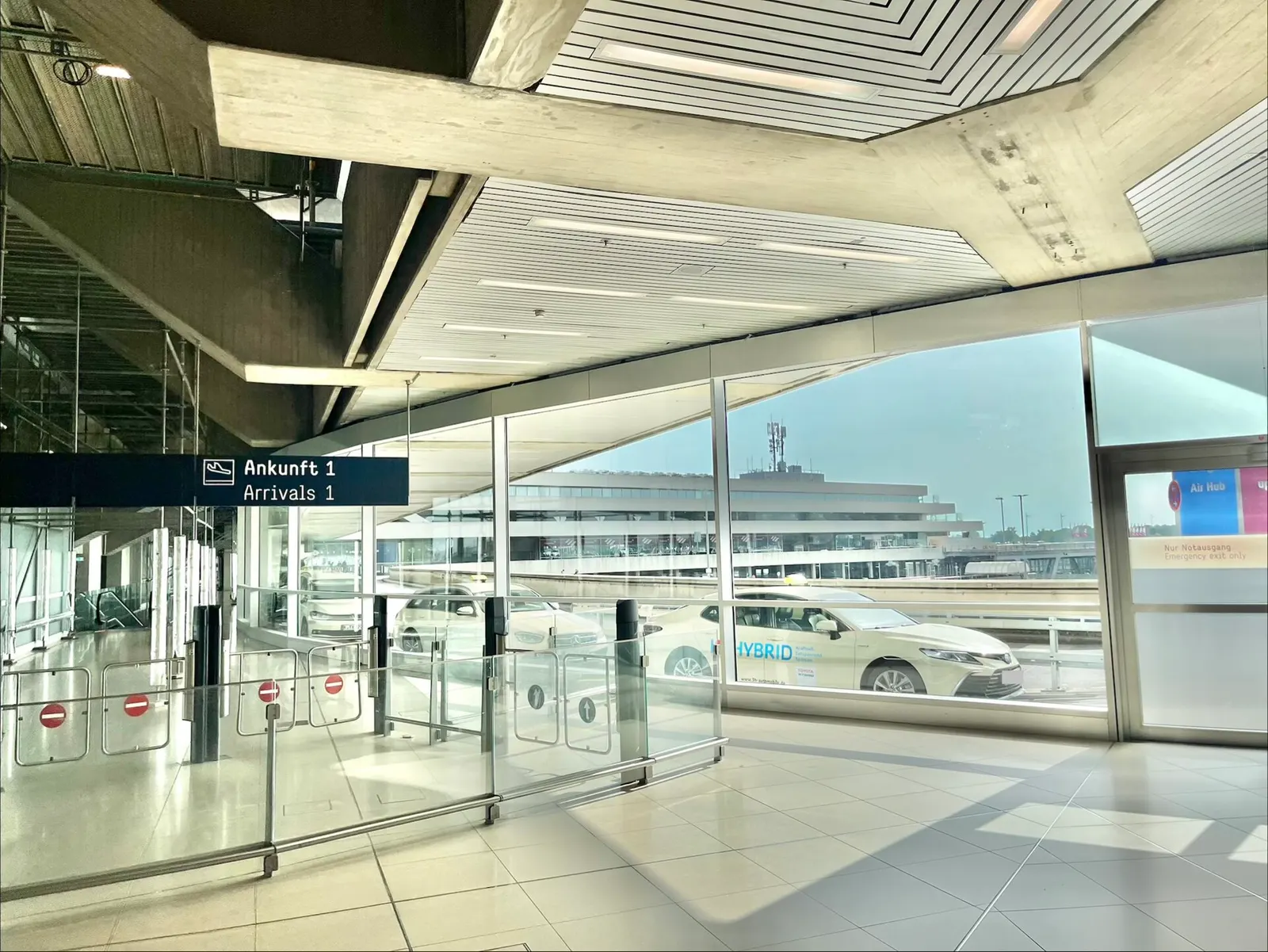The arrivals lounge at Cologne Bonn Airport with baggage reclaim areas and passenger circulation space.