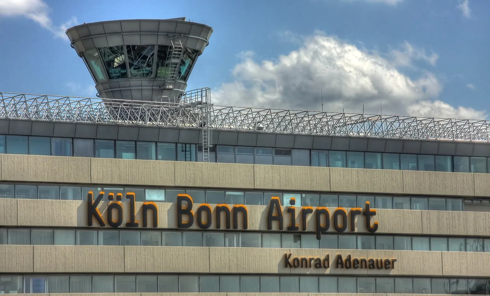 Large lettering reading Köln Bonn Airport Konrad Adenauer mounted on the facade of Terminal 1.