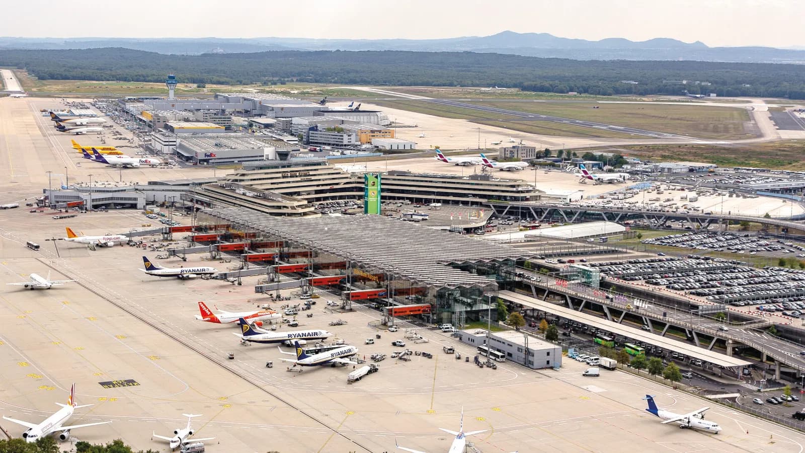 An aerial photograph showing the full layout of Cologne Bonn Airport, including runways, terminals, and surrounding roads.