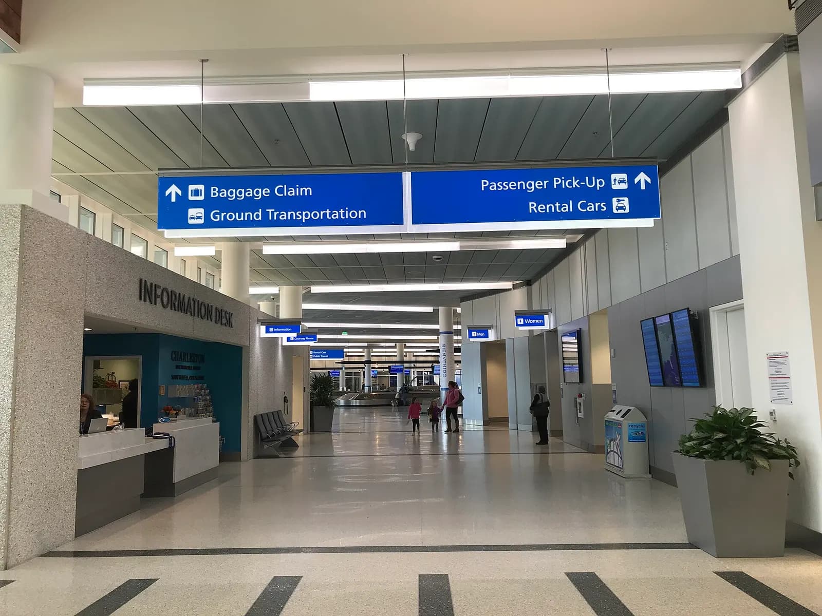 Landside hall at Charleston International with an Information desk and overhead signs for baggage claim, ground transportation, passenger pickup and rental cars.