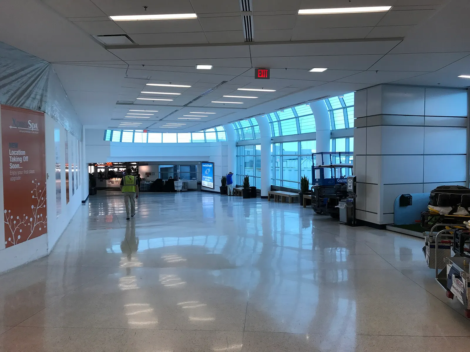 The bright central atrium at Charlotte Douglas International Airport with escalators and walkways leading toward Concourse E.