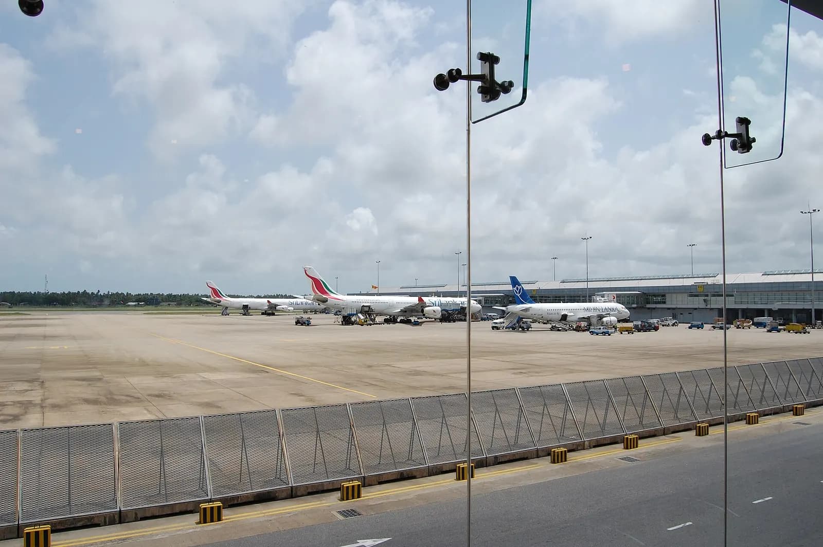 Apron view through terminal glass at Bandaranaike International Airport with SriLankan and Mihin Lanka aircraft