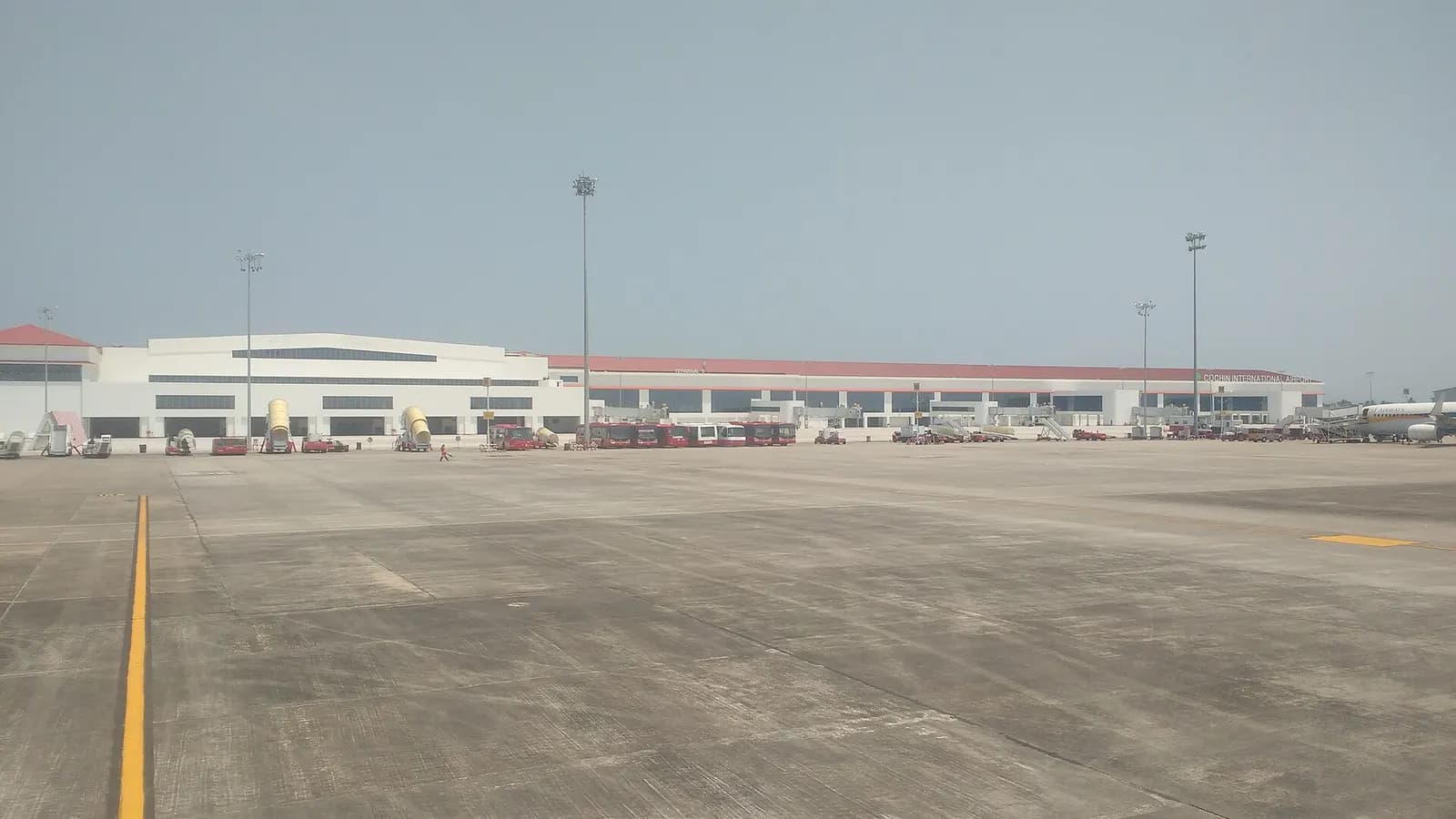 Cochin International Airport Terminal 3 airside facade with red Kerala-style roof and CIAL lettering