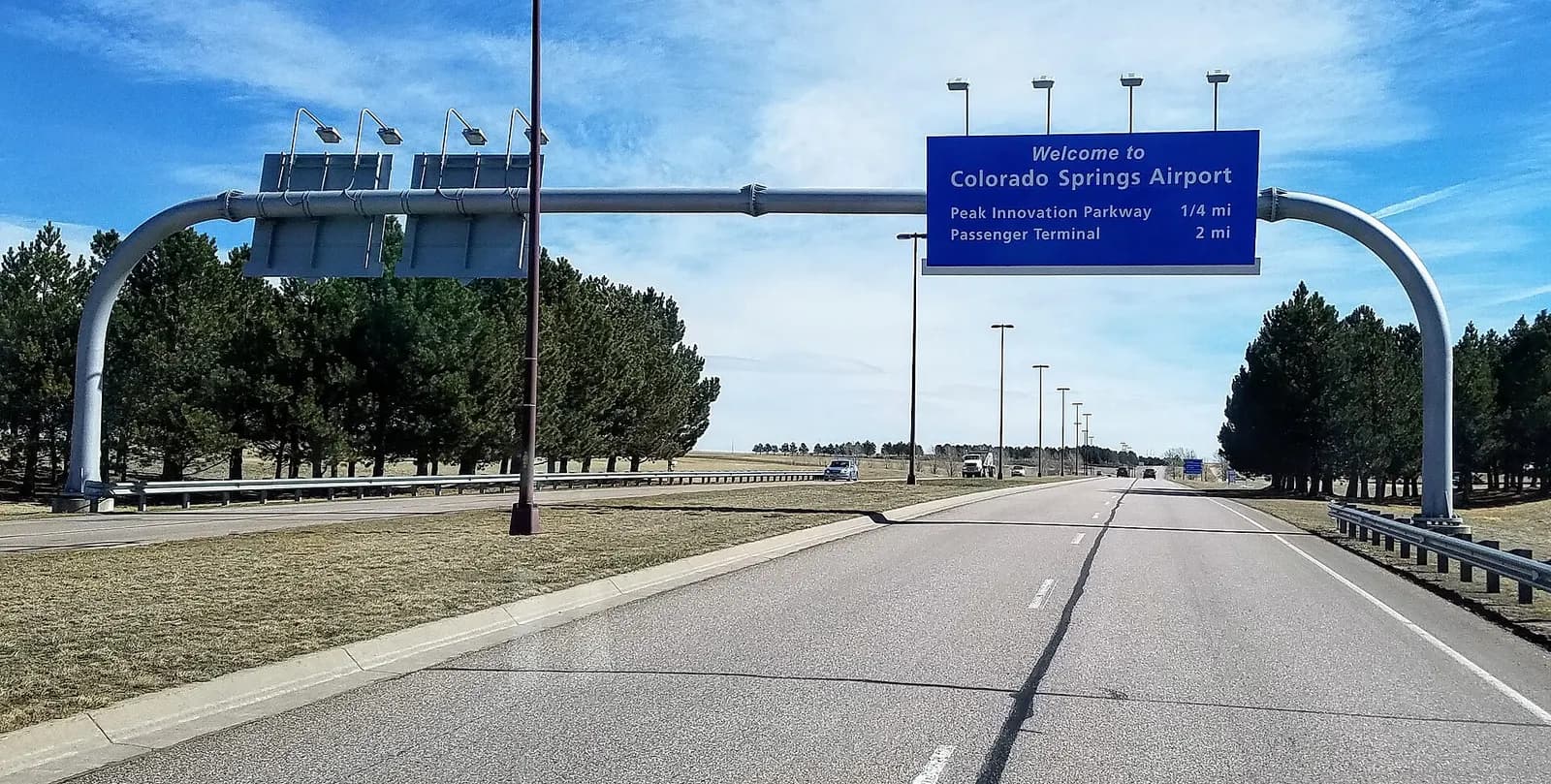 Overhead freeway sign reading Welcome to Colorado Springs Airport on the inbound approach road, March 2020.