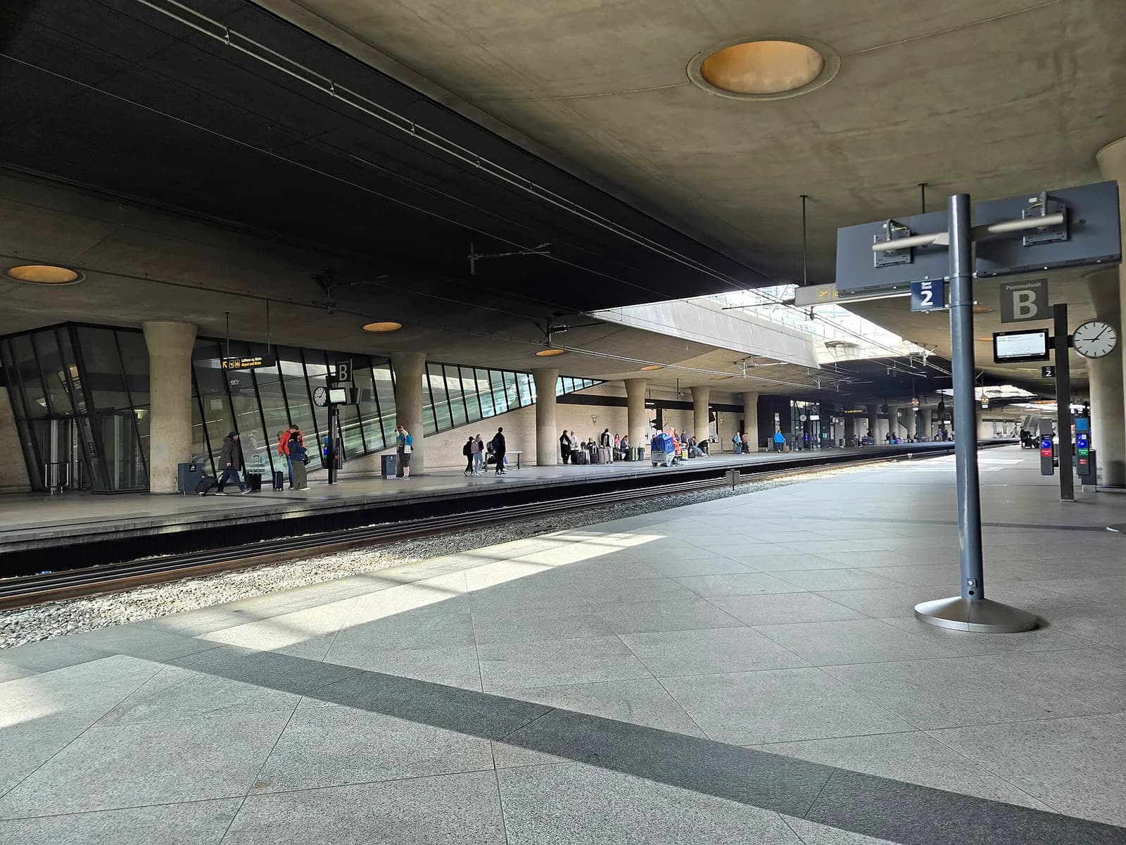 The platform, overhead signage, and tracks at Copenhagen Airport railway station in 2025.