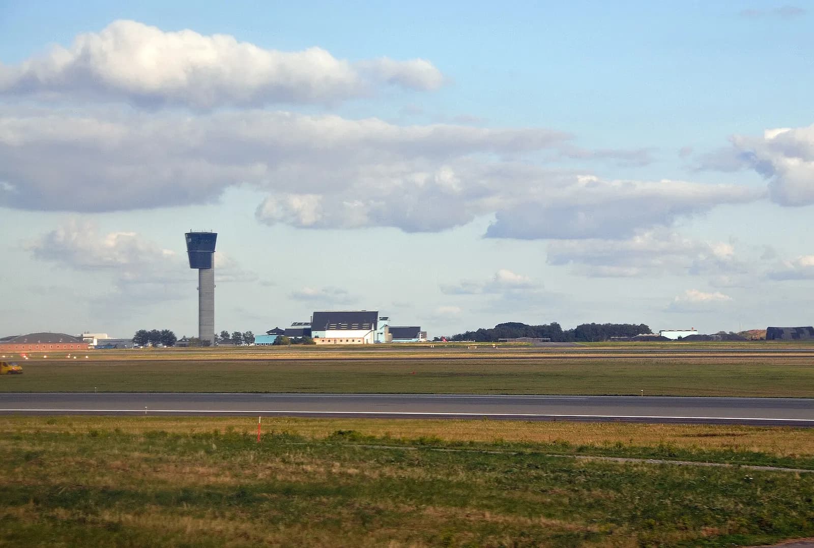 Travelers with luggage moving through the arrivals area inside Copenhagen Airport after landing.