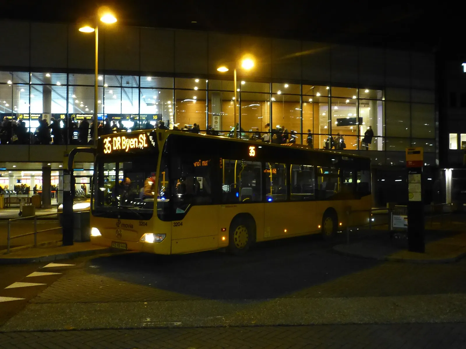 A Movia route 35 bus stopped outside Copenhagen Airport with the terminal building in the background.