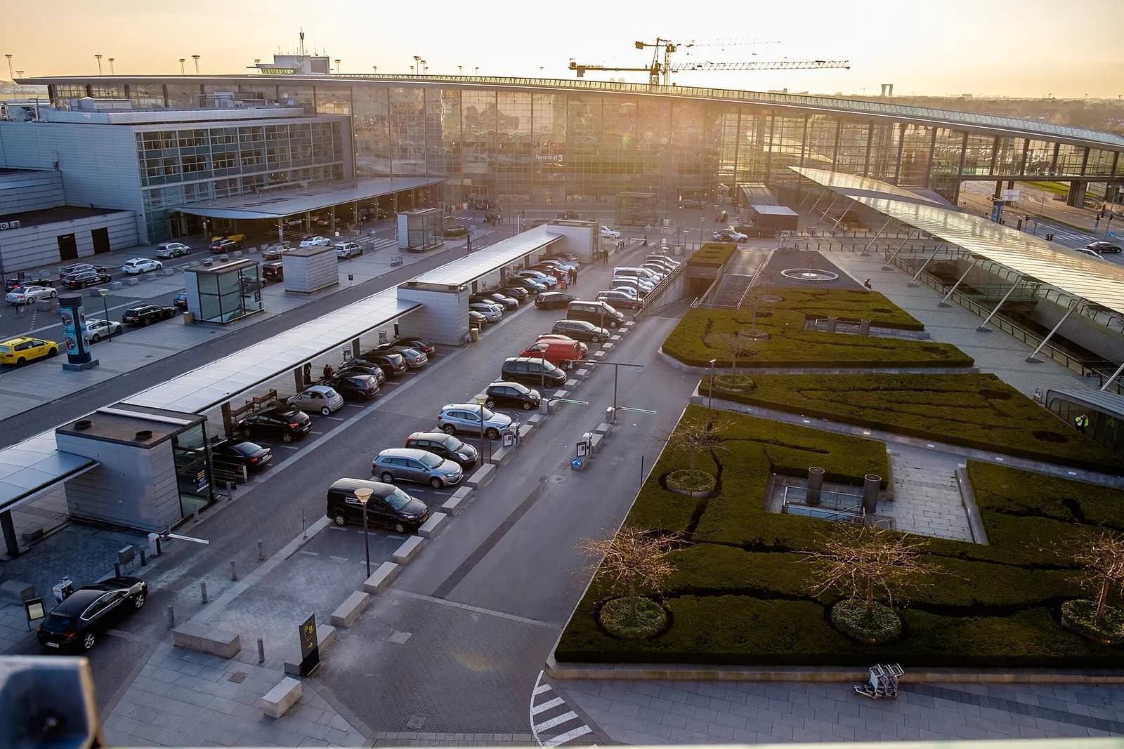 The bright, modern entrance and glass-fronted facade of Terminal 3 at Copenhagen Airport.