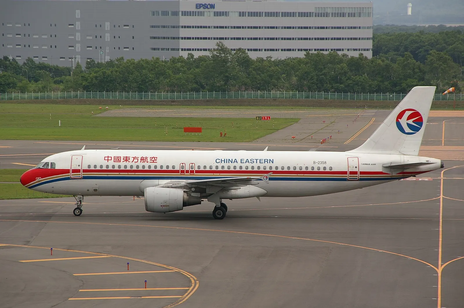Photograph of China Eastern Airlines ' Airbus A320-200 (B-2358) taken from the observation deck of New Chitose Airport passenger terminal building in Chitose, Hokkaido, Japan.
