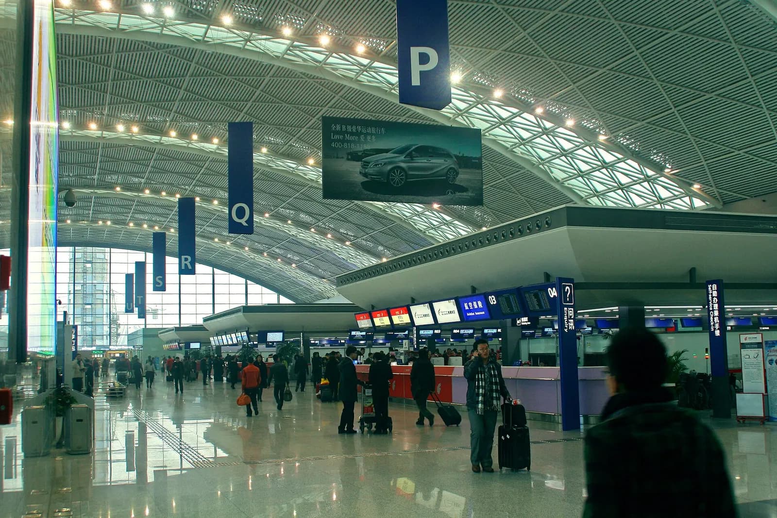 Rows of airline check-in counters with signage and queuing lanes inside Terminal 2's departure hall.