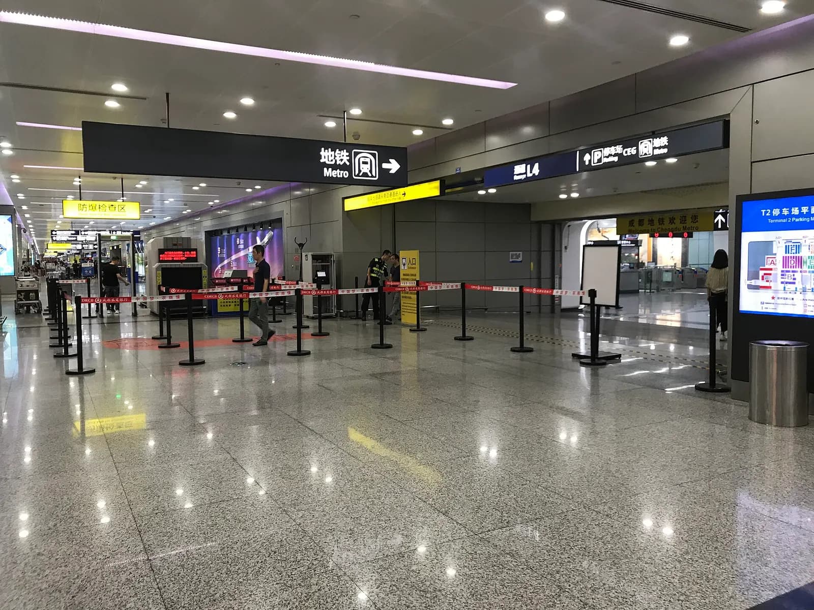 Landside security checkpoint inside Terminal 2 where passengers and bags are screened before entering the integrated metro and railway area.