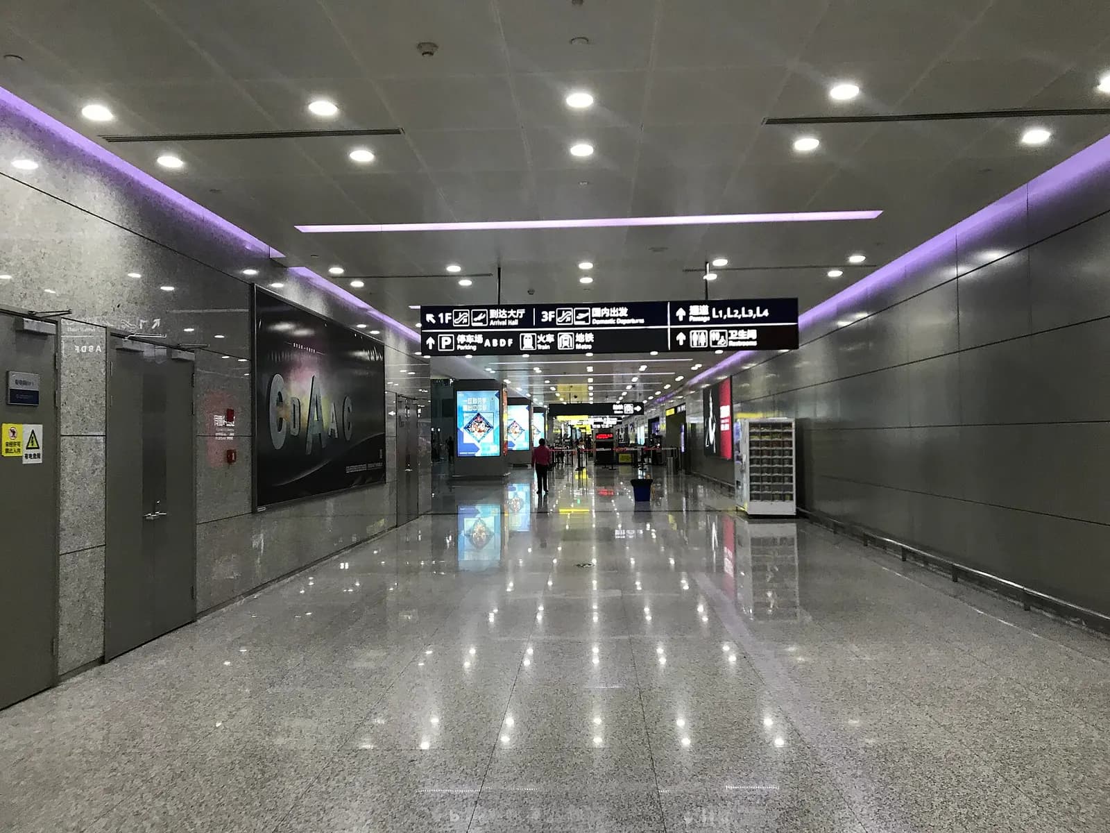 Ground transportation interchange on the B2 level of Terminal 2 with directional signs for metro, rail, taxis, and buses.