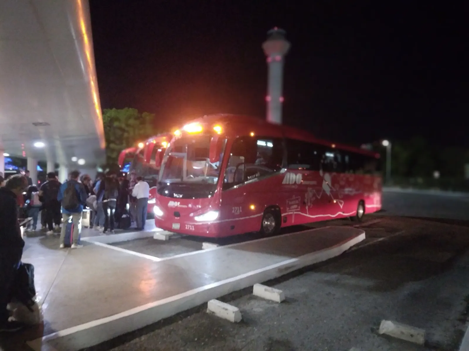 ADO intercity bus boarding platforms outside Terminal 2 at Cancún International Airport.