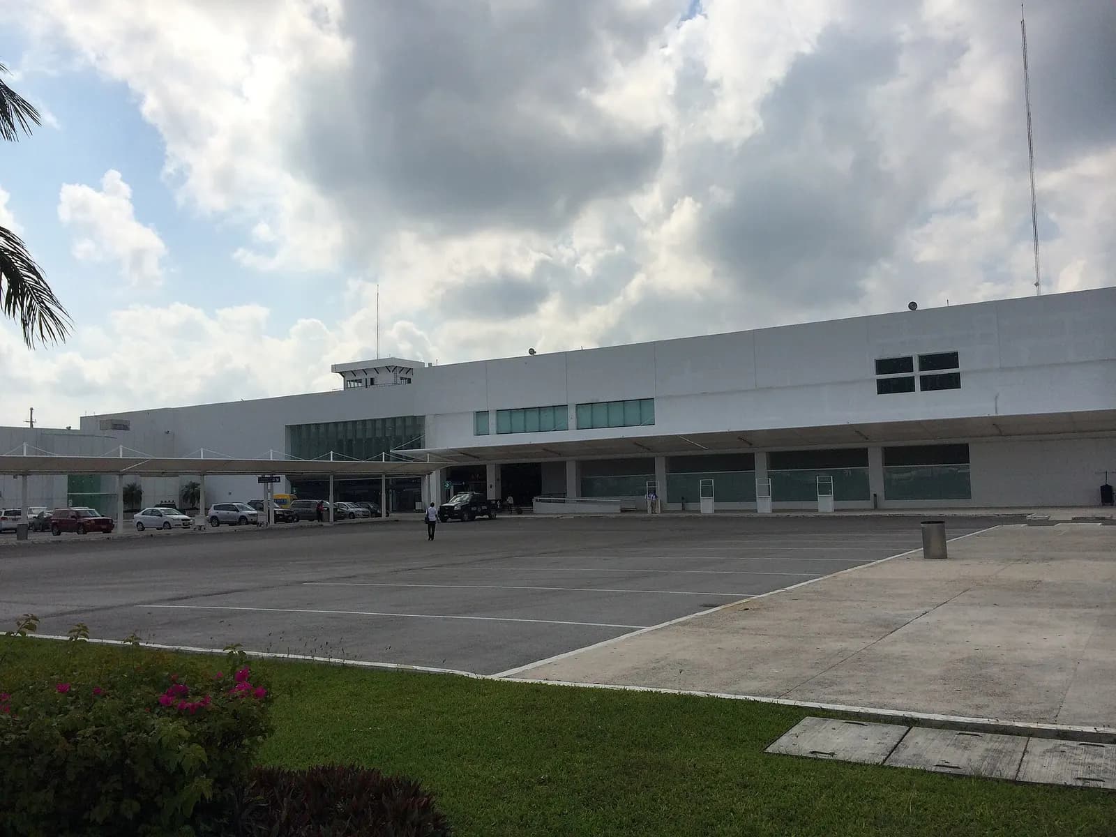 Landside exterior of Terminal 1 at Cancún International Airport viewed from ground level.