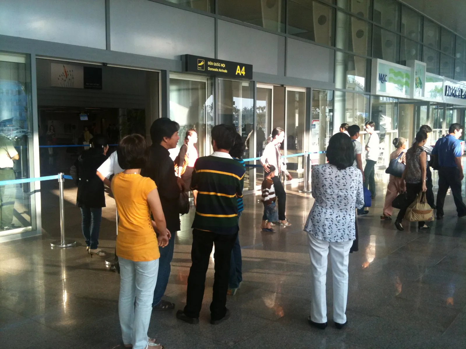 Visitors wait as passengers exit from the Arrivals hall of the newly constructed terminal at Danang International Airport.