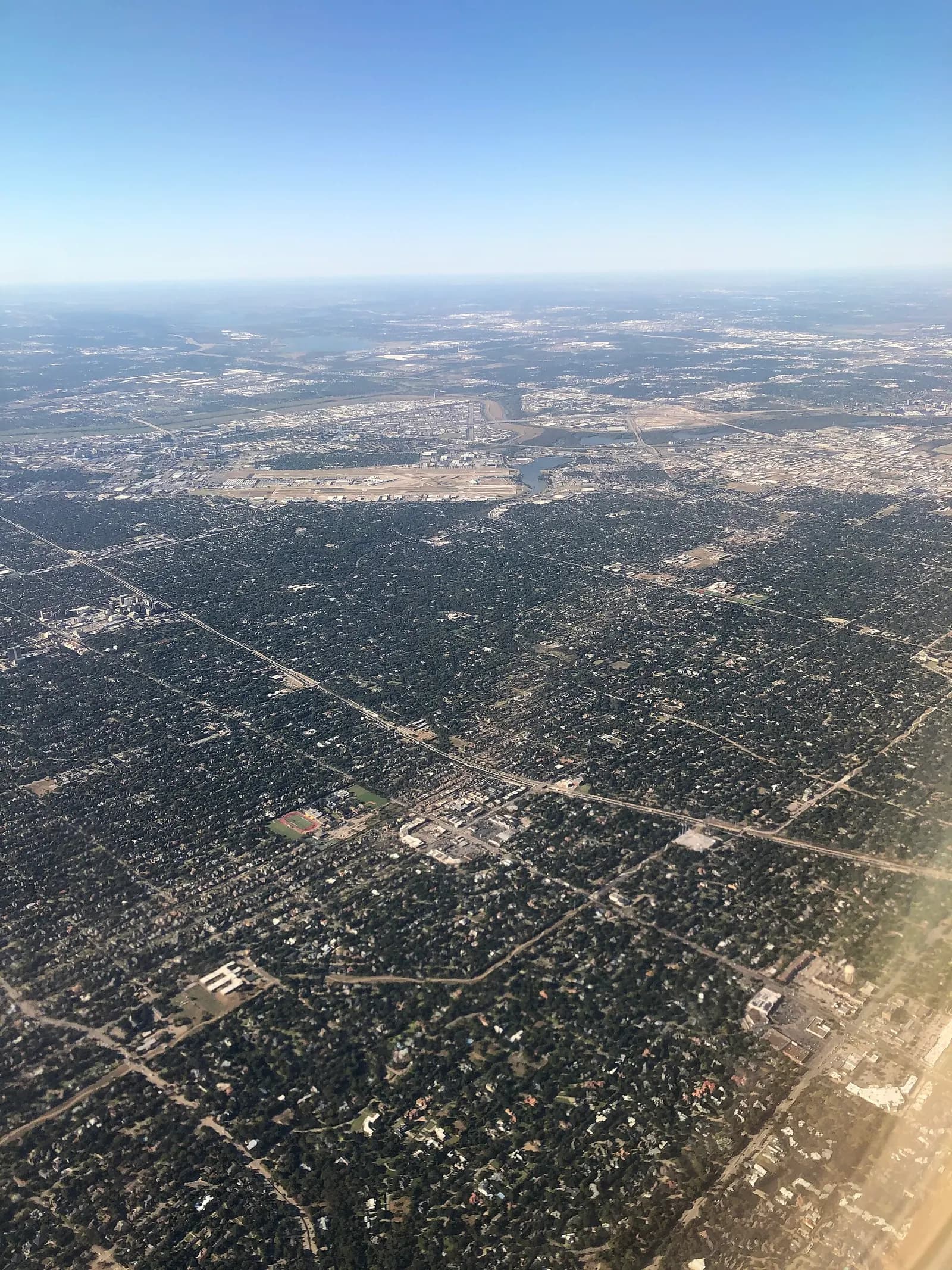 From the air the following morning, the path of tornado damage across North Dallas is visible. This view is looking south-west with the Dallas North Tollway across the middle, the Preston-Royal shopping plaza in the center, and Dallas-Love Field airport in the distance. The tornado travelled from to