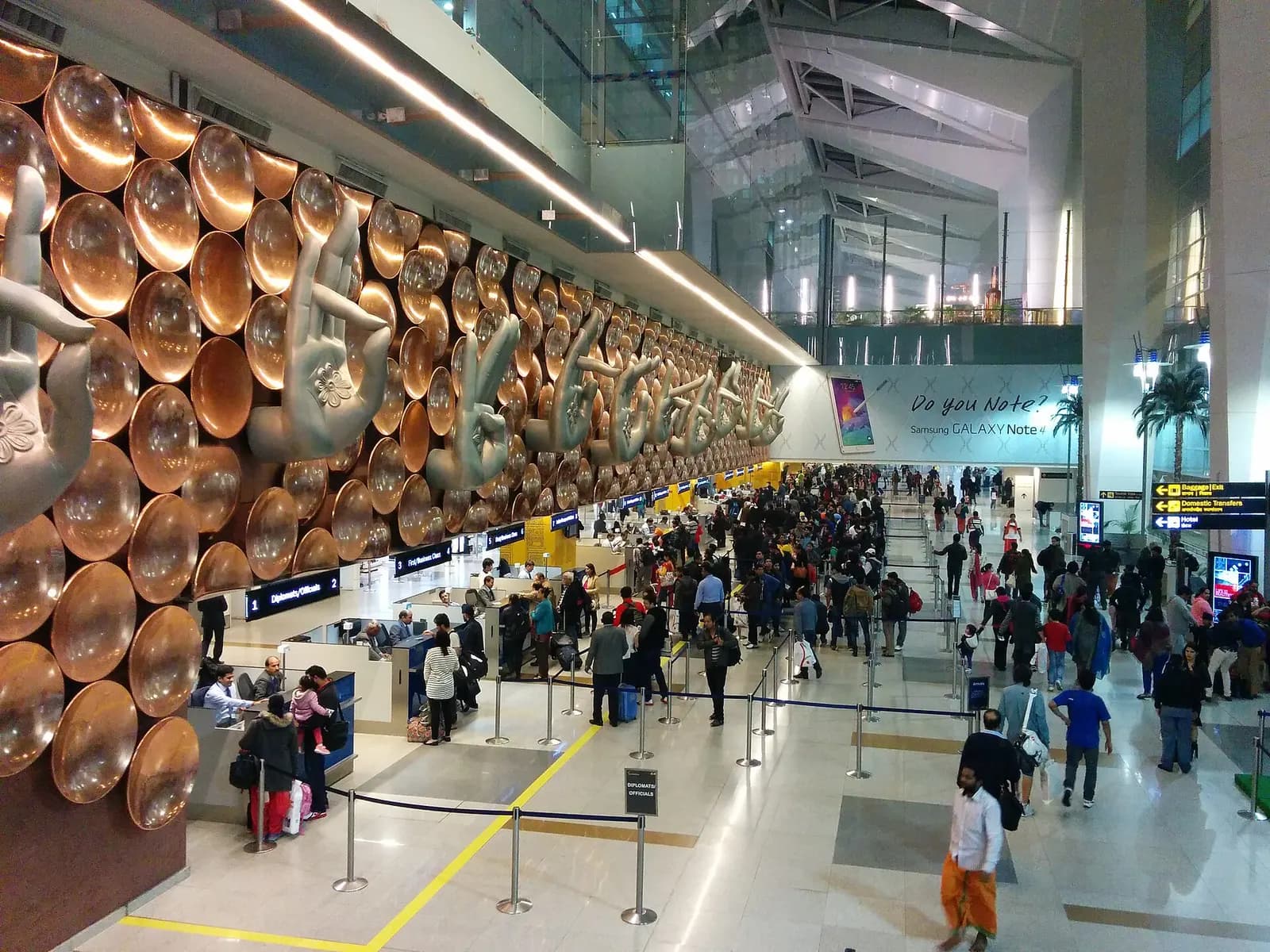 Immigration and passport control booths with queuing lanes where arriving passengers are processed at Indira Gandhi International Airport.