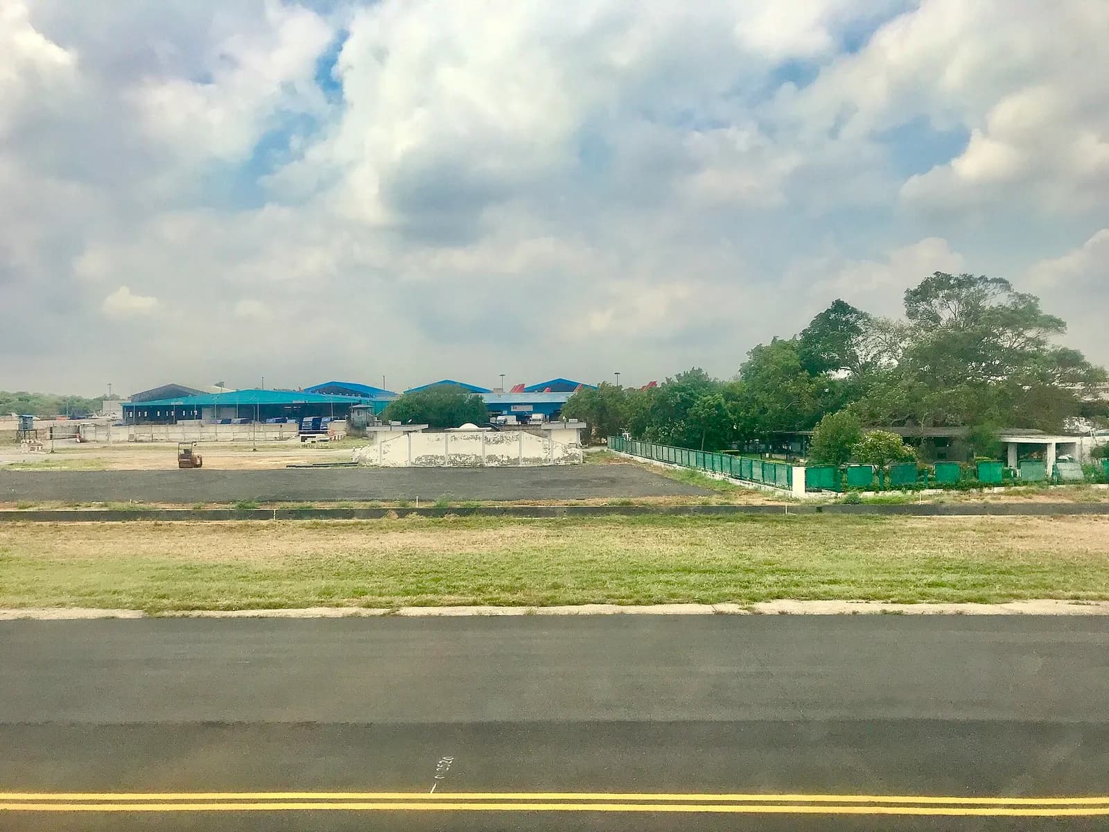 View from the runway showing terminal buildings, taxiways, and the broader airfield layout of Indira Gandhi International Airport.