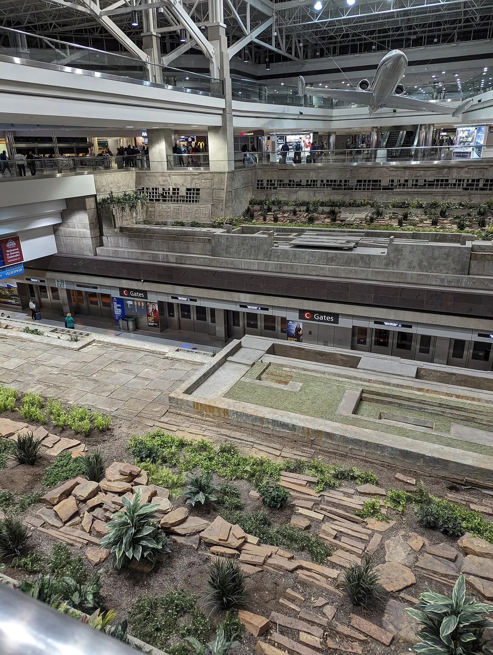 An elevated overlook shows the Concourse C station platform for Denver International Airport's automated people mover.