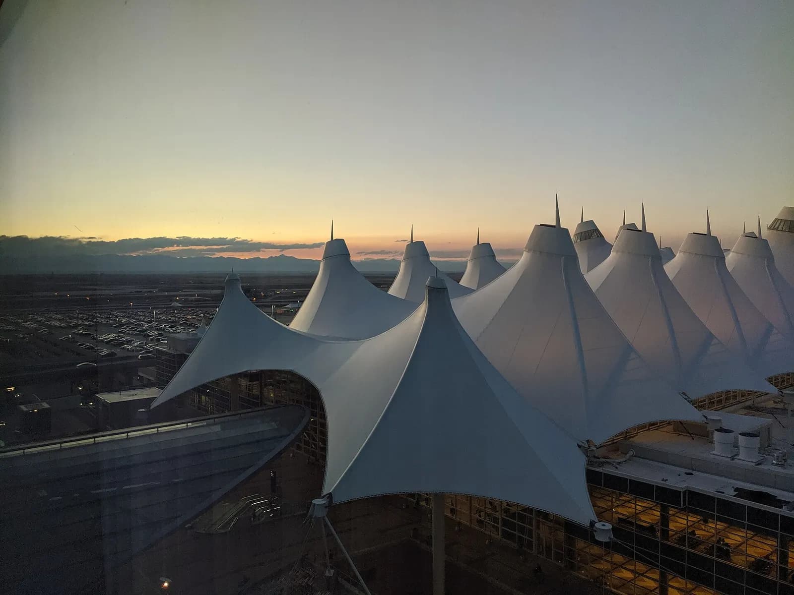 The illuminated Jeppesen Terminal and adjacent Westin hotel are seen at dusk from a high floor of the Westin Denver International Airport.