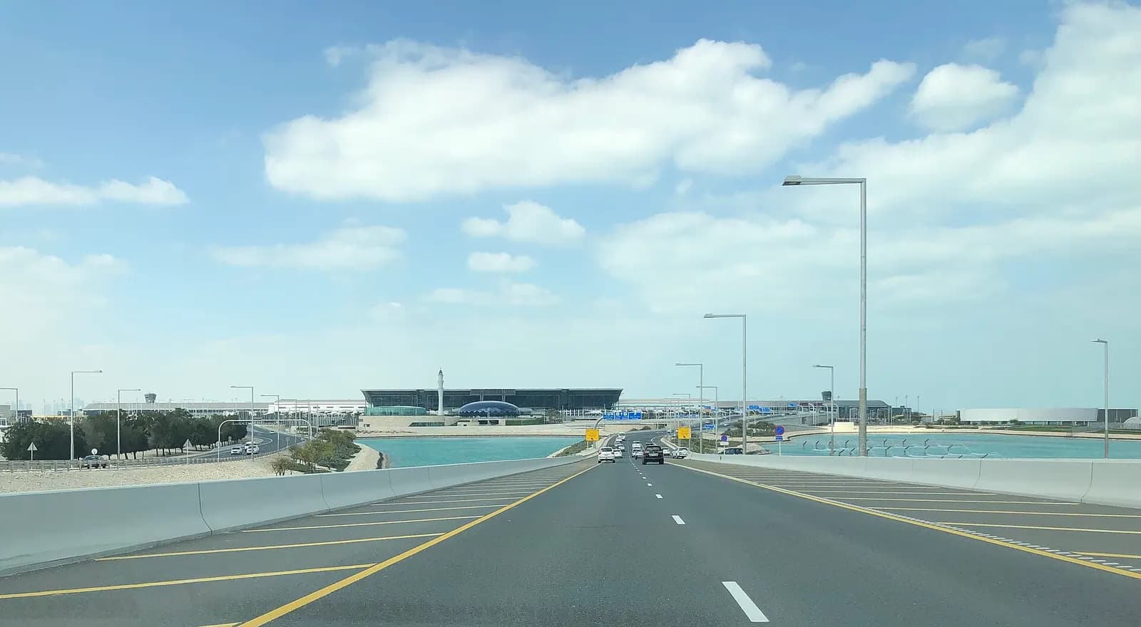 The curved, contemporary terminal building of Hamad International Airport viewed from outside.