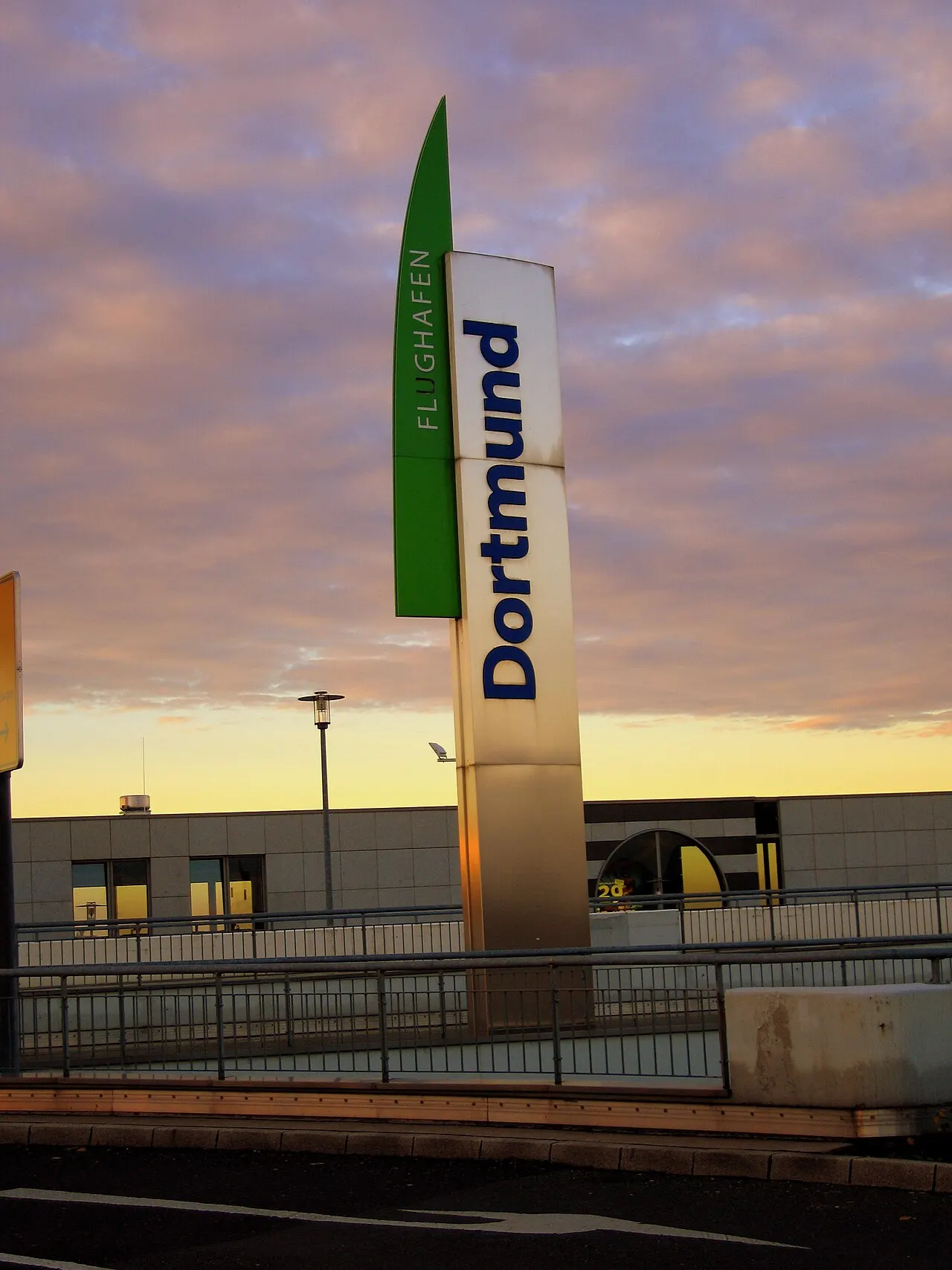 Evening FLUGHAFEN Dortmund roadside identification sign in front of the terminal