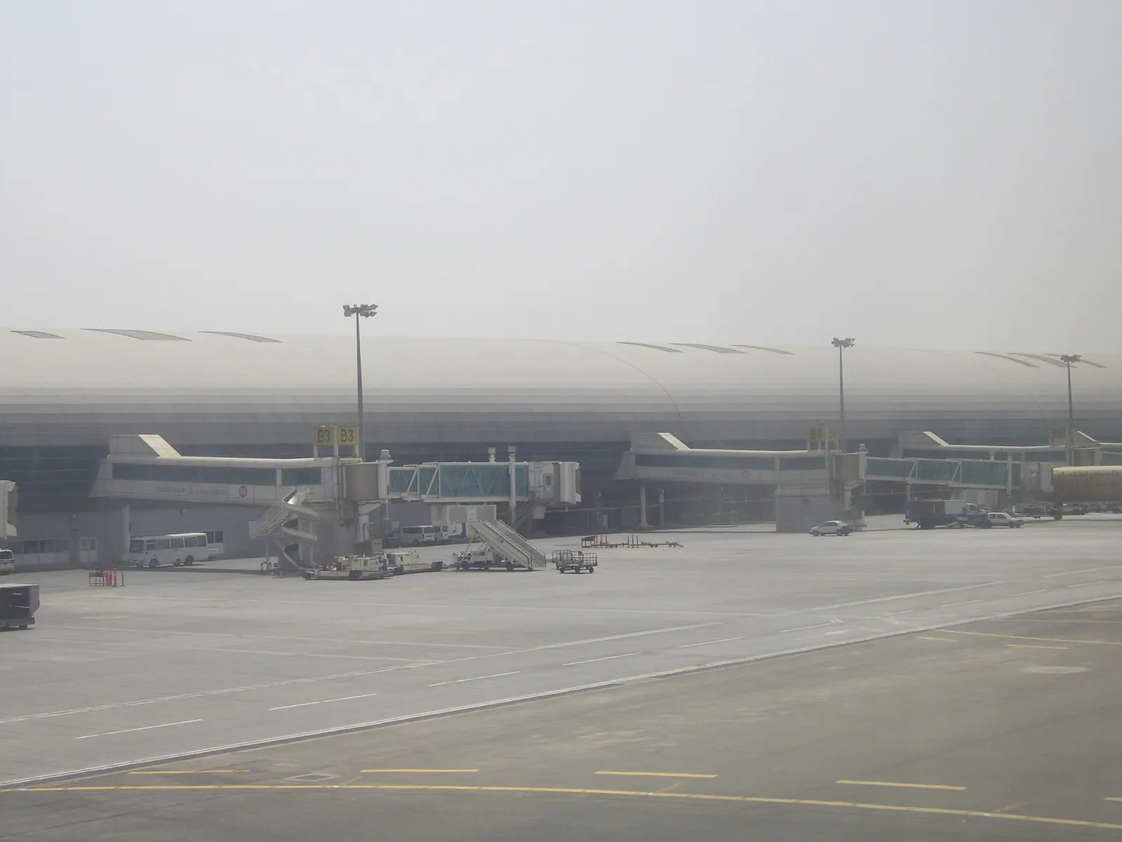 A bright Terminal 1 concourse corridor with gate seating areas and departure signage along Concourse C.