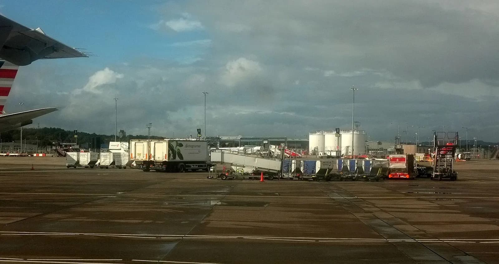 The Edinburgh Airport terminal complex and airfield seen from ground level under a cloudy sky.