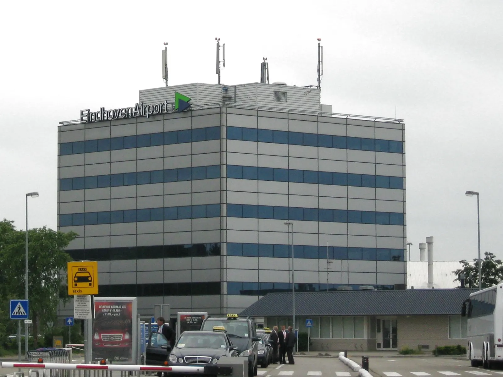 Exterior of the Eindhoven Airport terminal building under a clear sky.