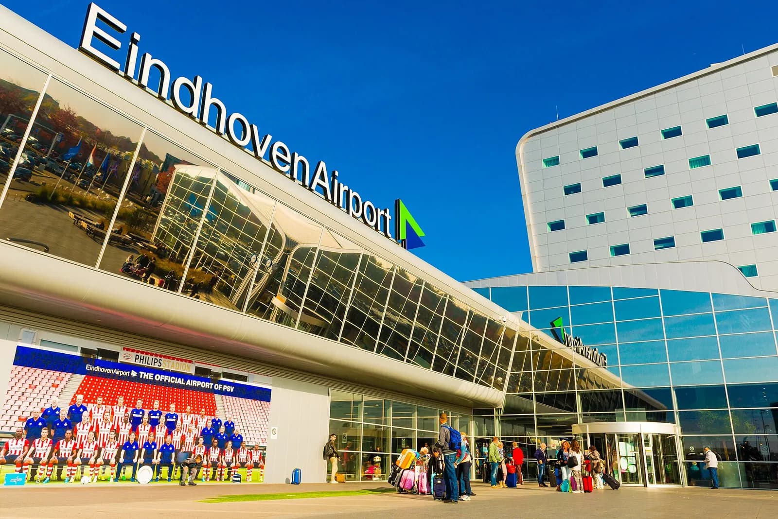 Front façade of the Eindhoven Airport passenger terminal with glazed entrance and canopy.