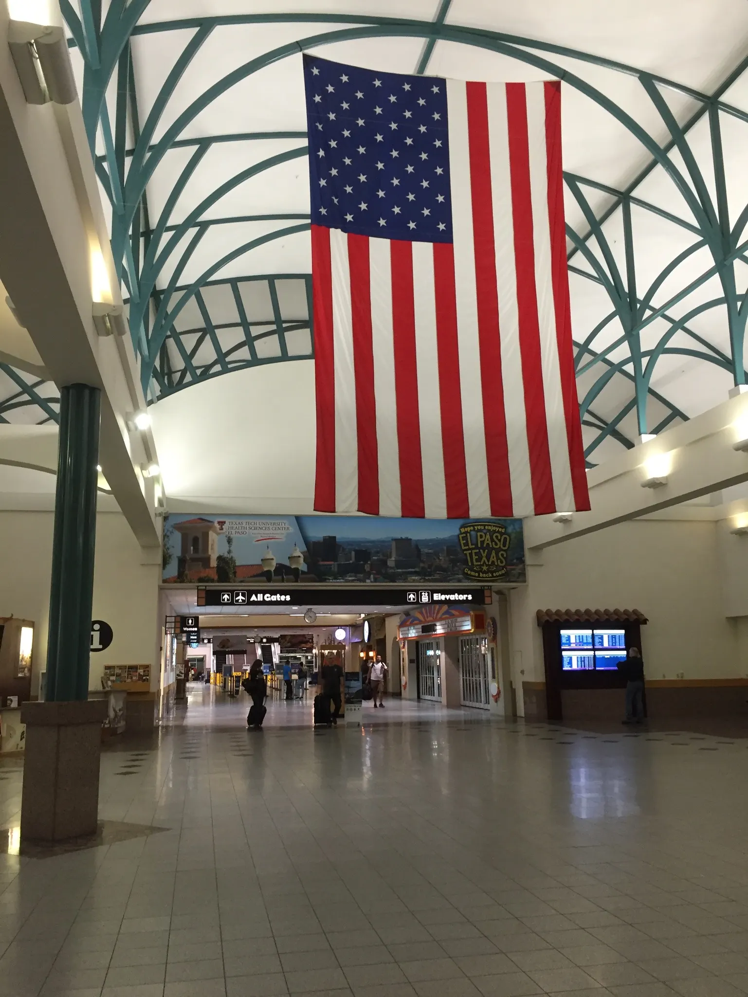 Interior corridor of El Paso International Airport with seating and overhead wayfinding.