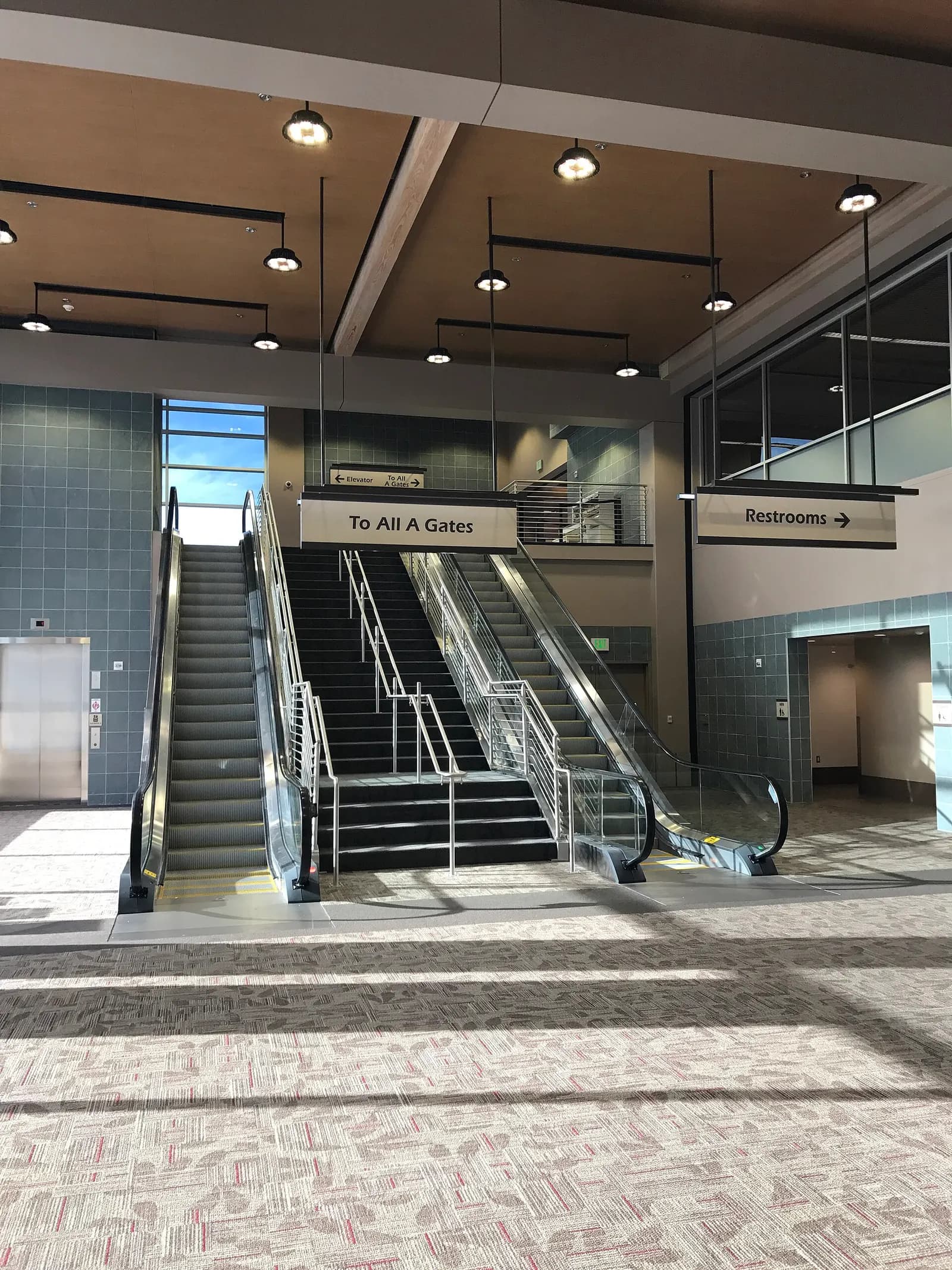 Escalator and stairs signed To All A Gates inside Eugene Airport in October 2016.