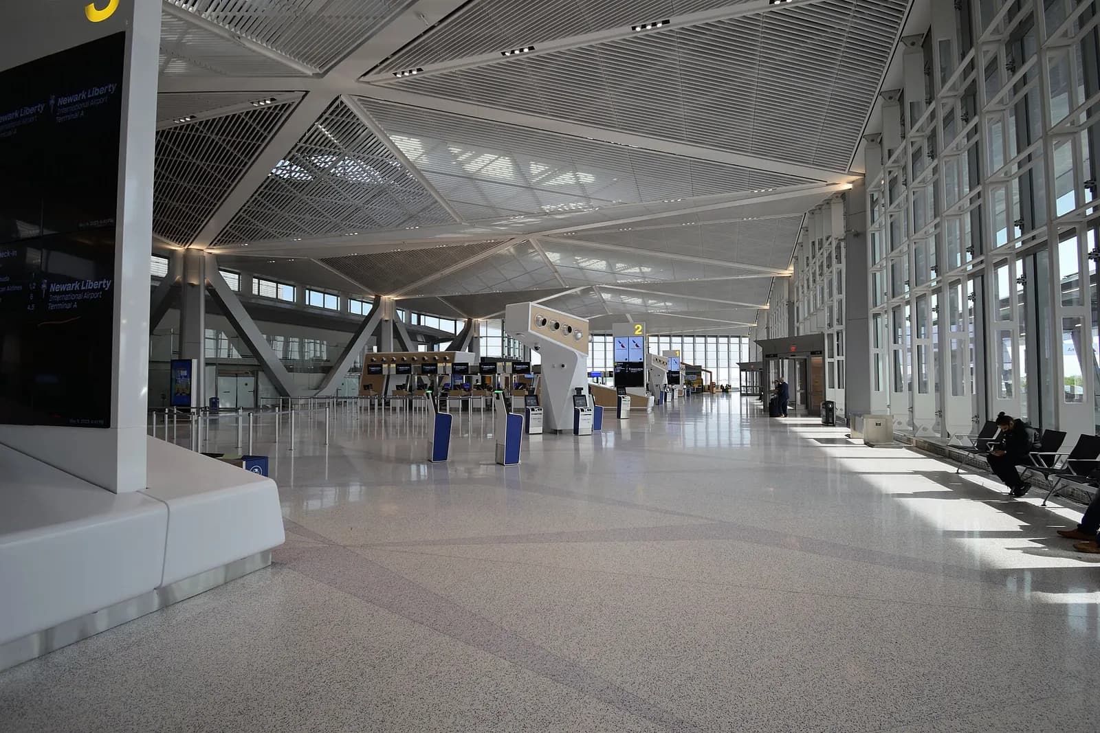 The bright, open upper level of the new Terminal A with check-in counters, departure boards, and a high glass ceiling.