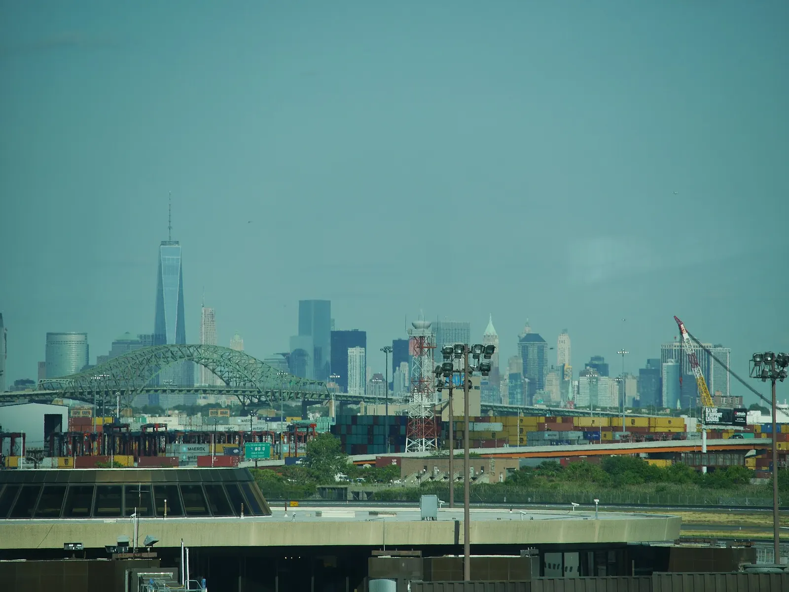The Manhattan skyline visible in the distance beyond the airport runways and taxiways on a clear day.