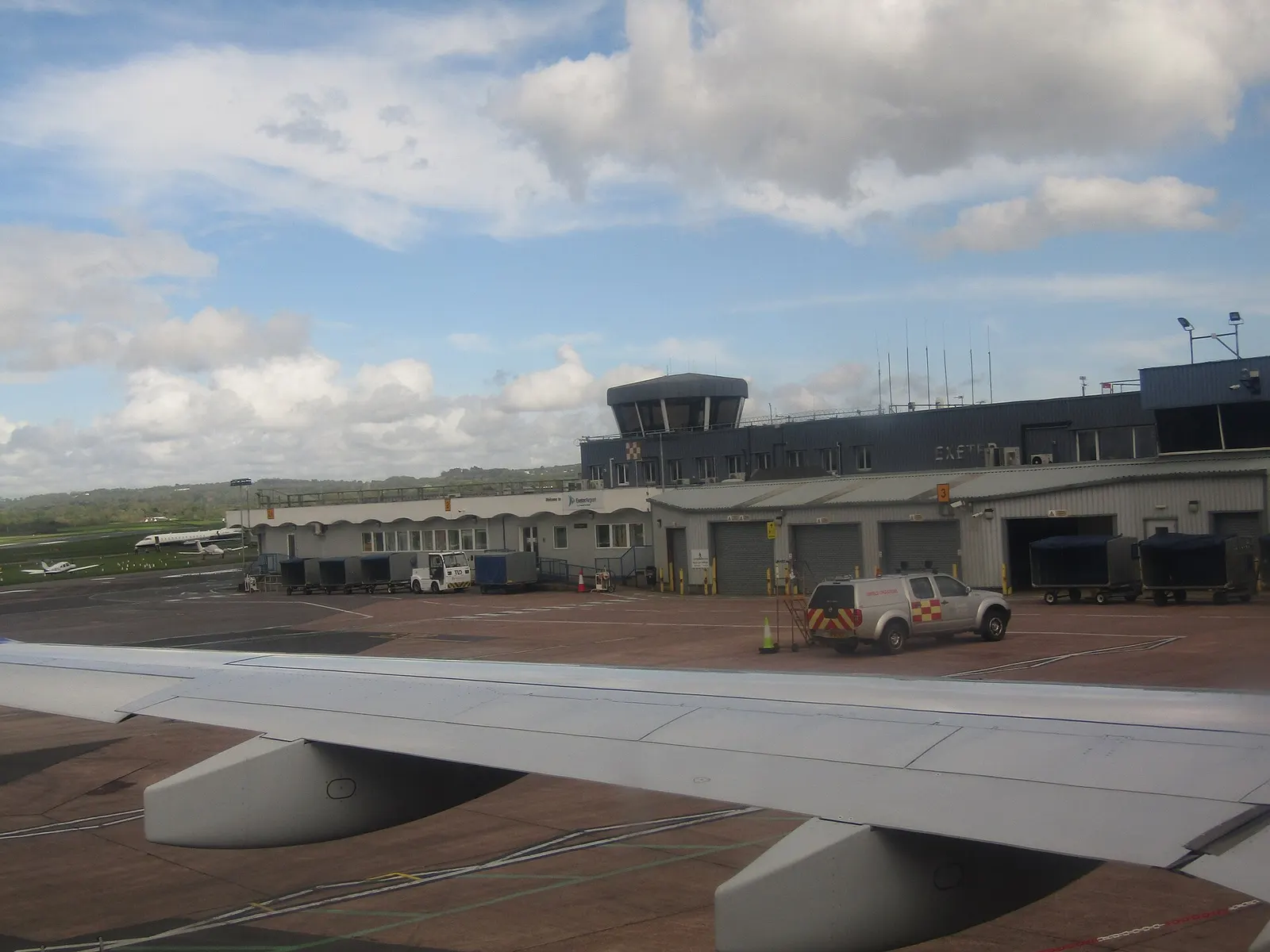 The control tower and terminal buildings of the airport in the city of Exeter , Devon, England.