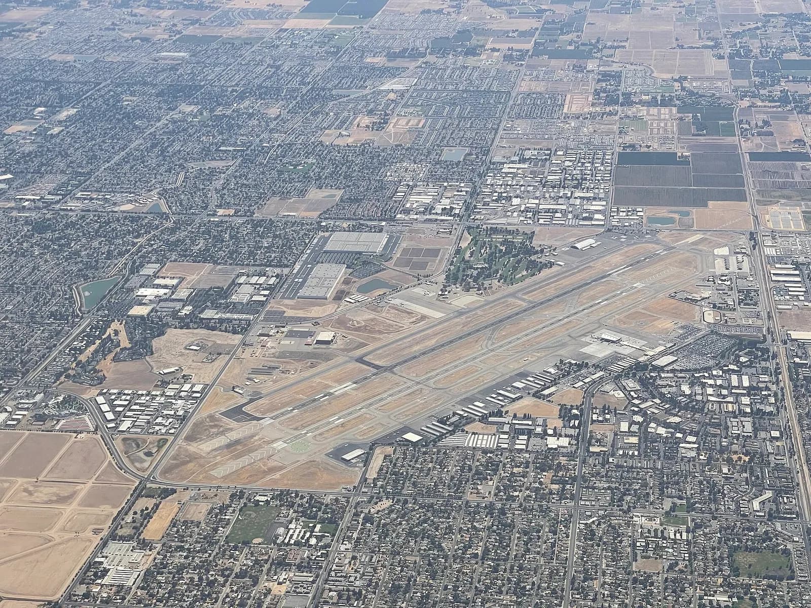 Aerial view of Fresno Yosemite International Airport showing two parallel runways and the civil terminal.