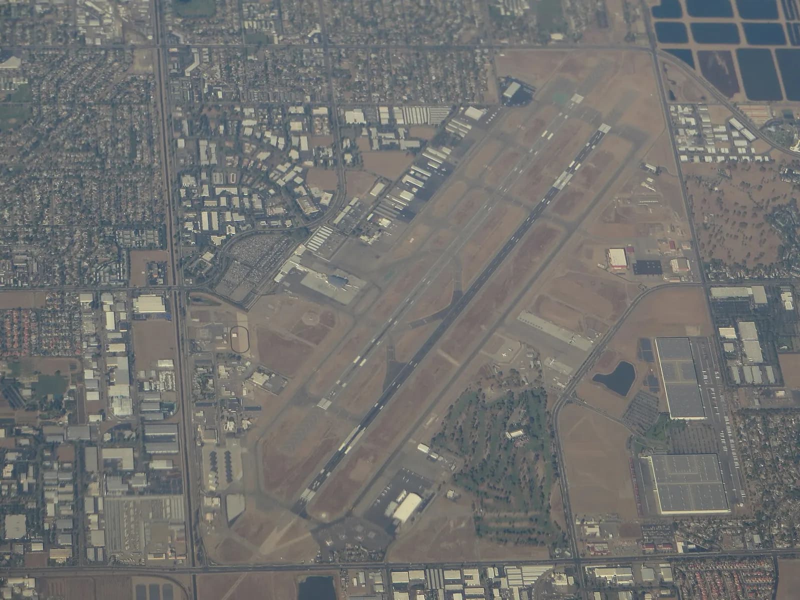 Landside exterior of Fresno Yosemite International Airport with the terminal canopy and roadway in daylight.