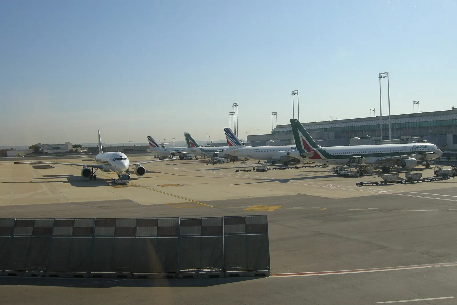 Exterior of Rome Leonardo da Vinci–Fiumicino Airport with terminal facades and surrounding airfield infrastructure.