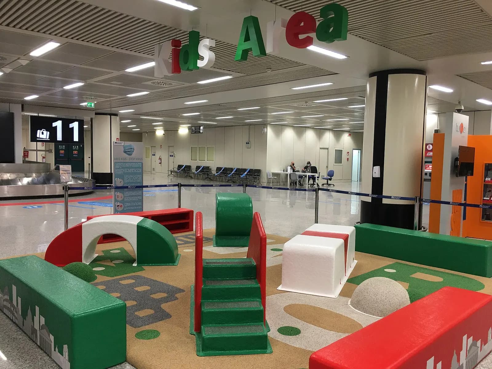 A colorful children's play area inside Fiumicino Airport with kid-sized furniture and activity equipment.