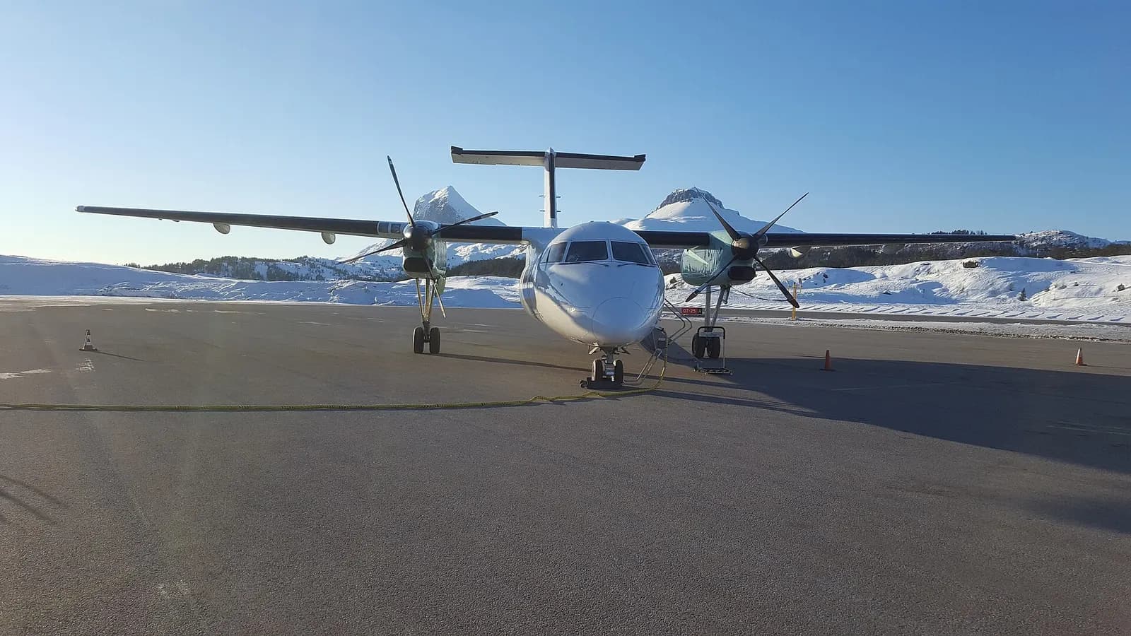 Dash 8 Q100 at Førde Airport during Winter 2018 with the Mountains Kvamshestane in the background.