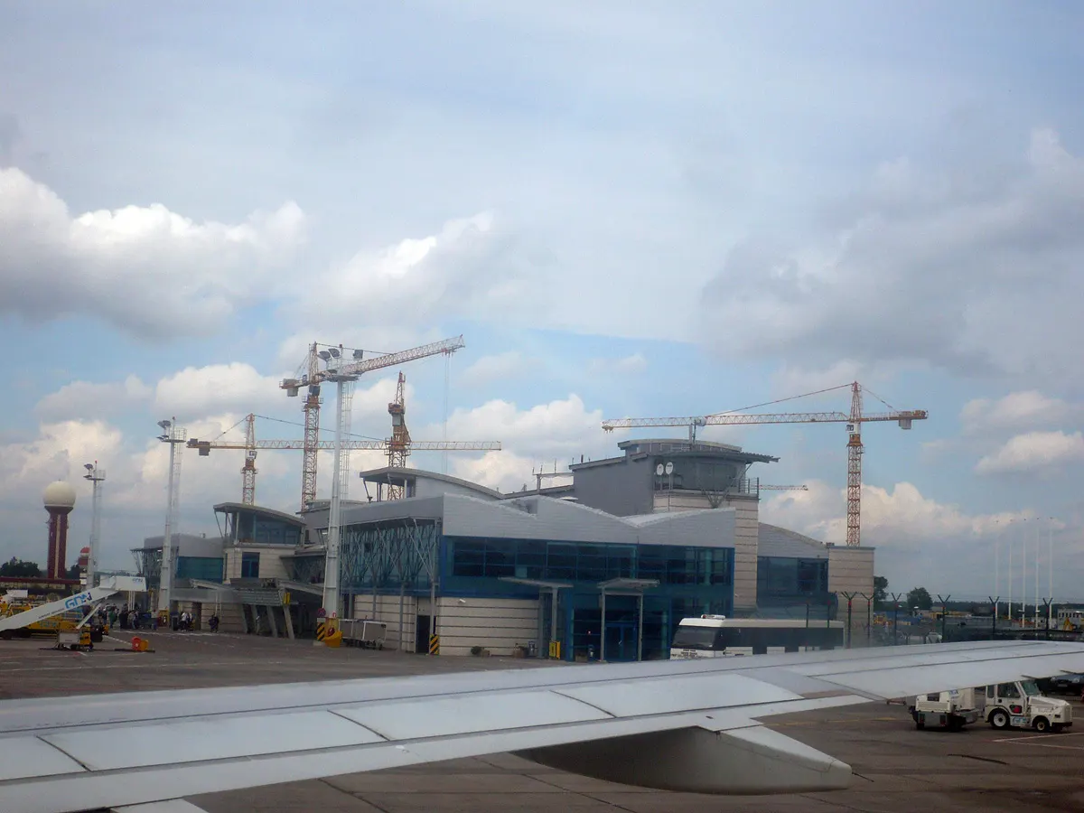 View from an aircraft on the ramp toward the Gdańsk airport passenger terminal buildings and surrounding tarmac.