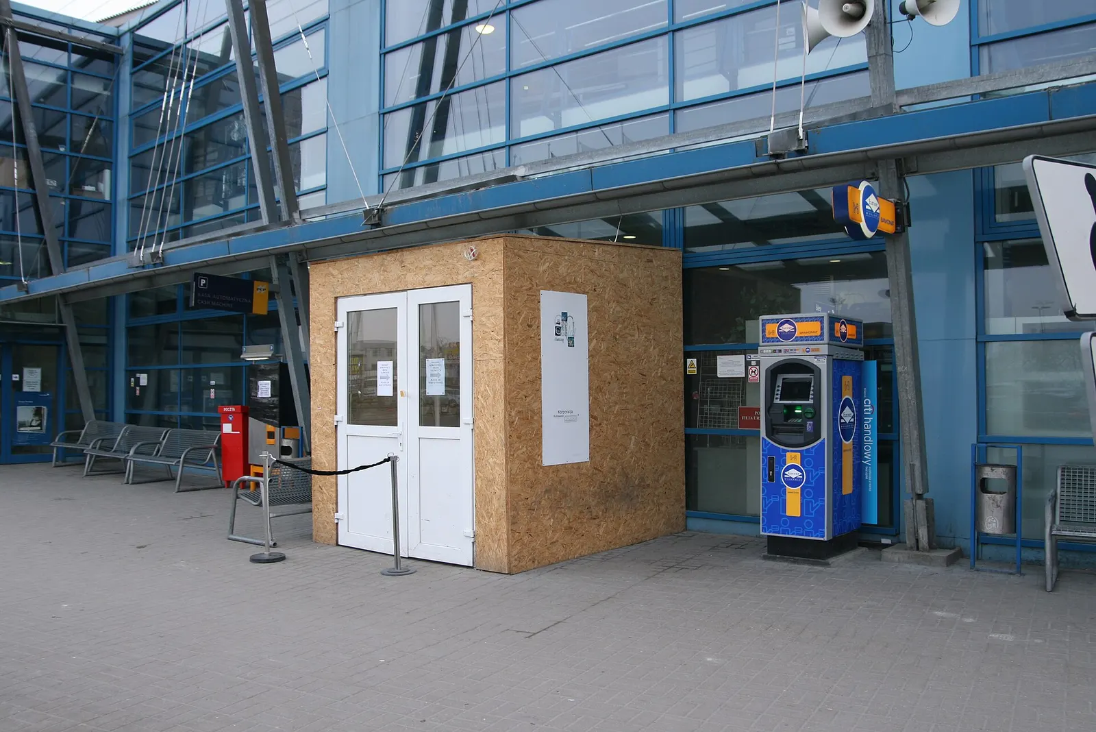 Road approach and entry area leading into Gdańsk Lech Wałęsa Airport with signage and the terminal visible ahead.