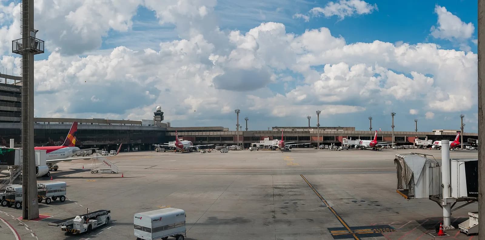 Wide panoramic view of Galeão International Airport showing passenger terminals, runways, and aircraft parked on the aprons.